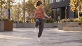 Танцовщица исполняет шаг Running Man в шаффле на городской площадке
